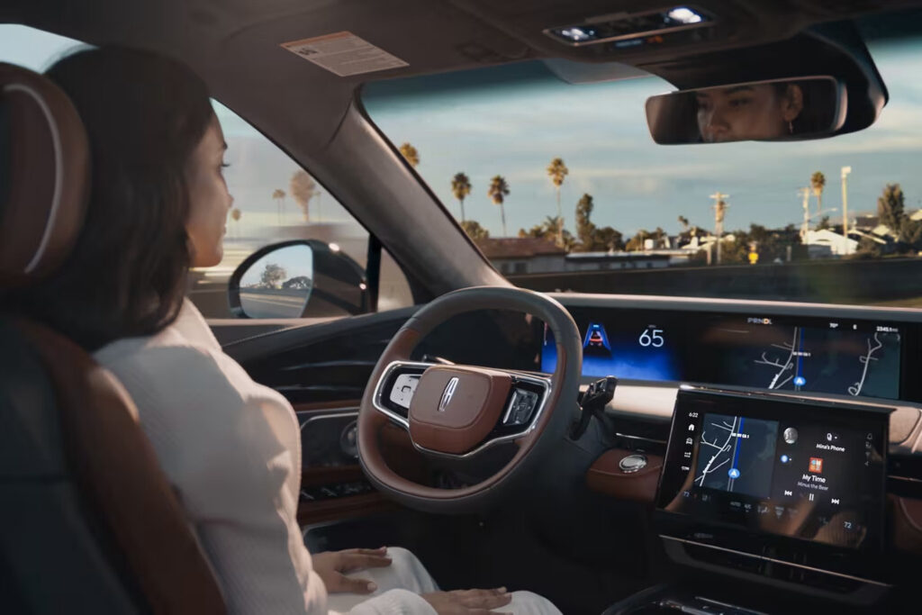Woman in self-driving car using navigation system, dashboard displays speed and map route.
