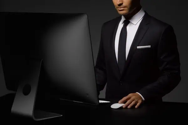 Businessman in a suit using a desktop computer, emphasizing professionalism and technology.